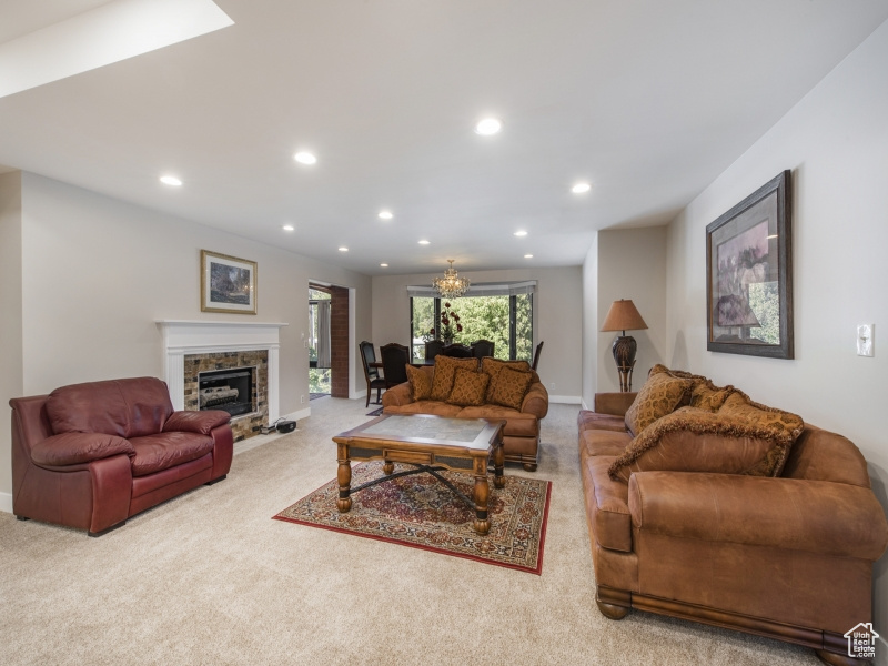 Carpeted living room with a notable chandelier