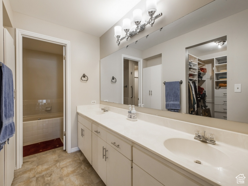 Bathroom featuring vanity and a relaxing tiled tub