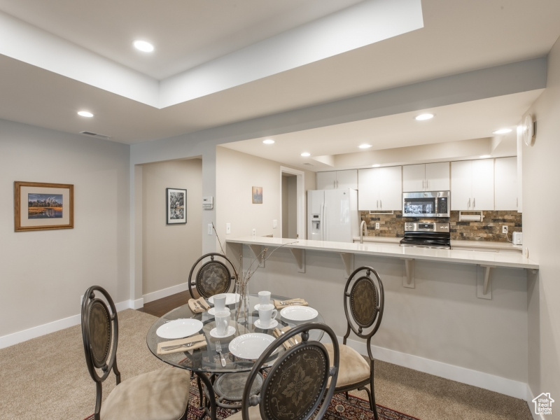 Dining space featuring light carpet and sink