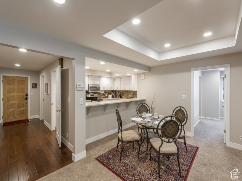 Dining space featuring hardwood / wood-style floors and a tray ceiling