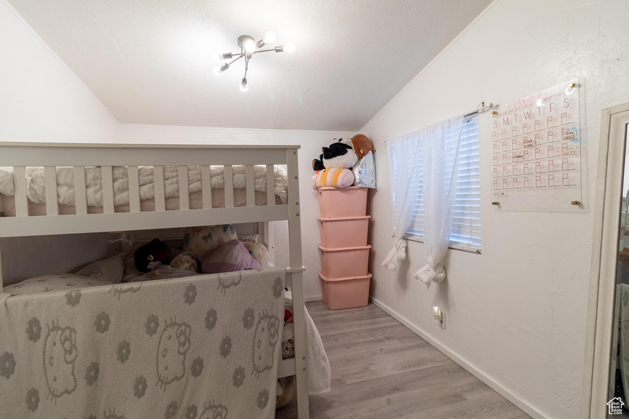 Second bedroom featuring lofted ceiling and wood-style flooring