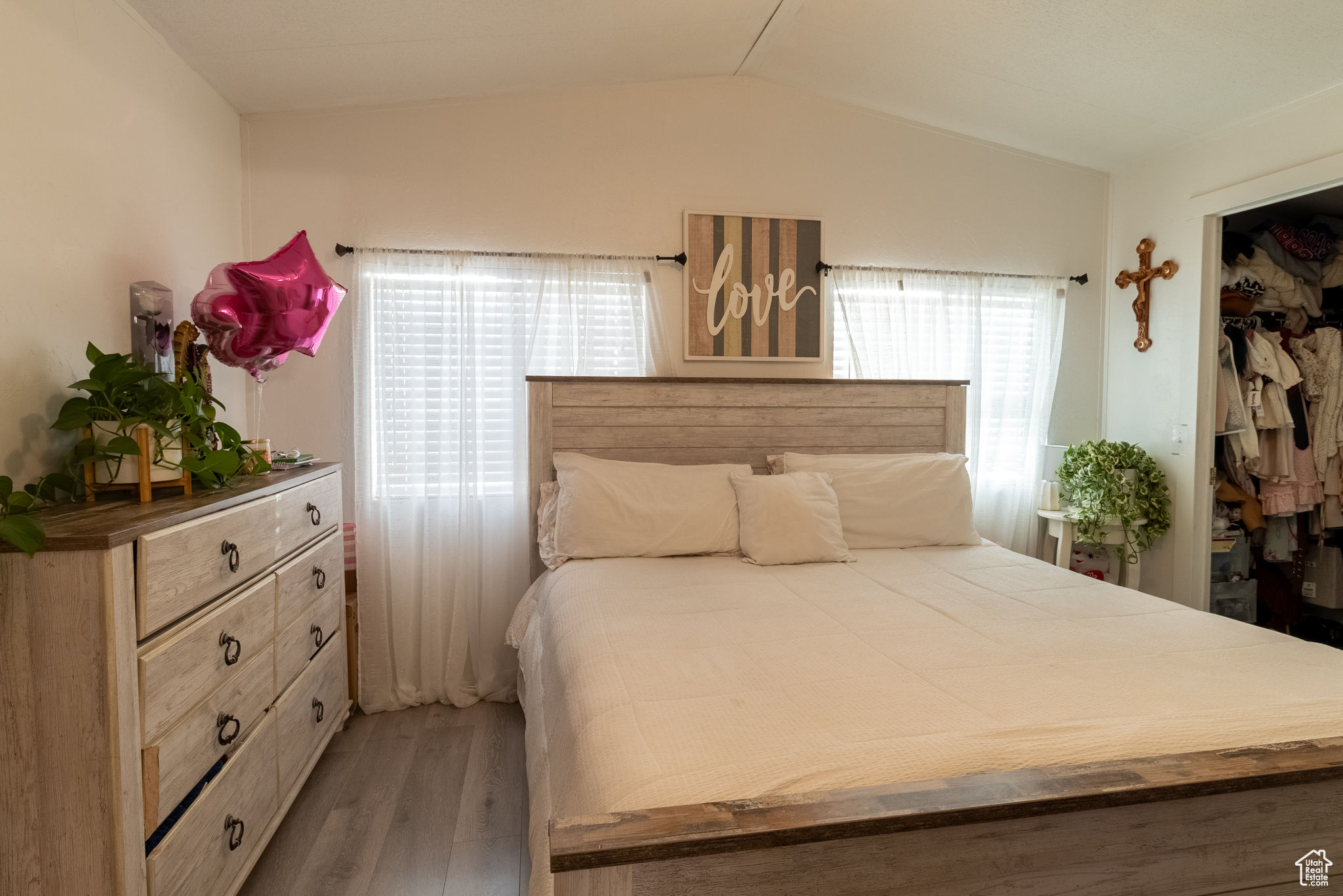 Master bedroom featuring closet, wood-type flooring, and vaulted ceiling