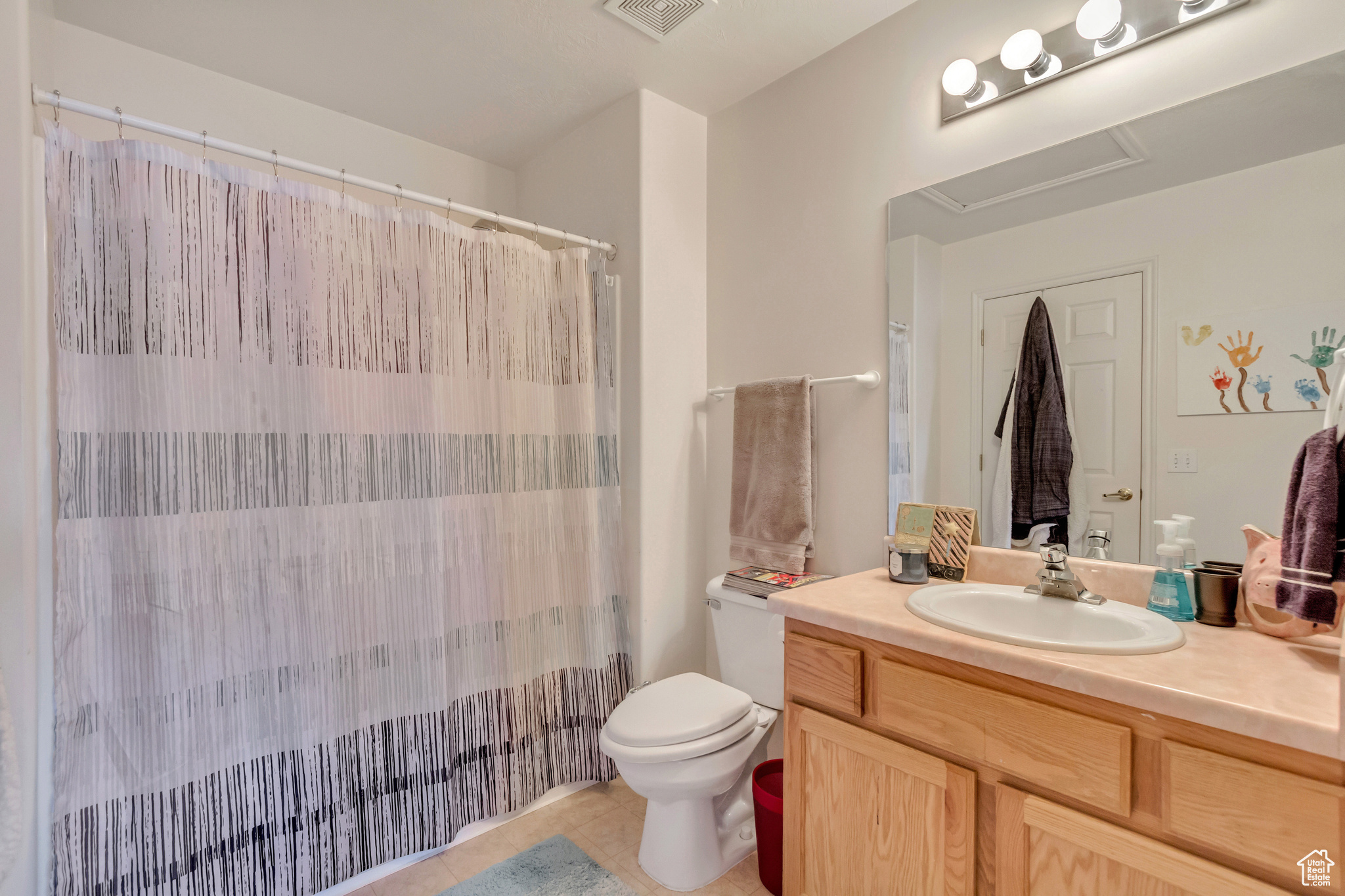 Bathroom with toilet, vanity, and tile patterned floors