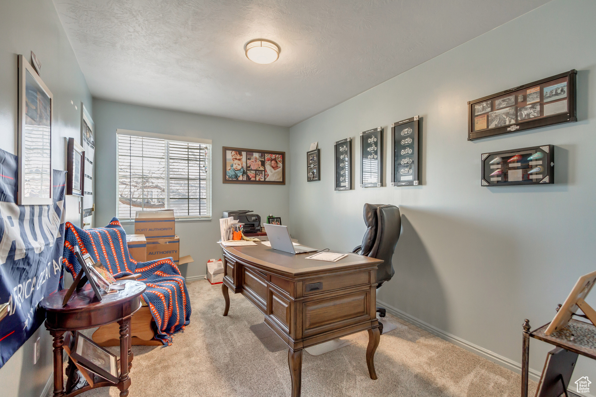 Office area featuring a textured ceiling and light carpet