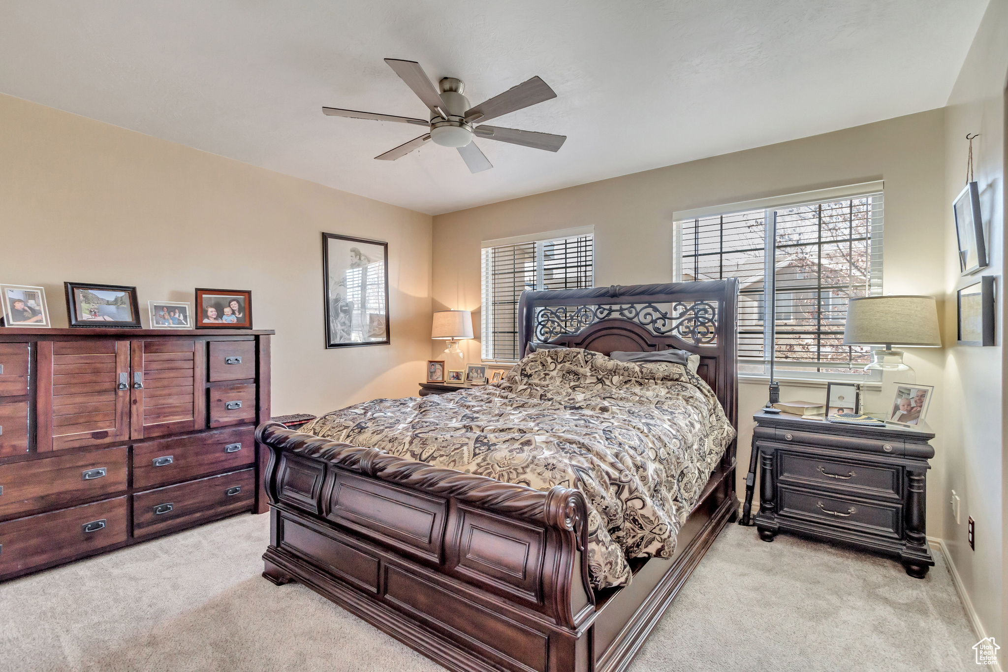 Bedroom featuring multiple windows, ceiling fan, and light colored carpet