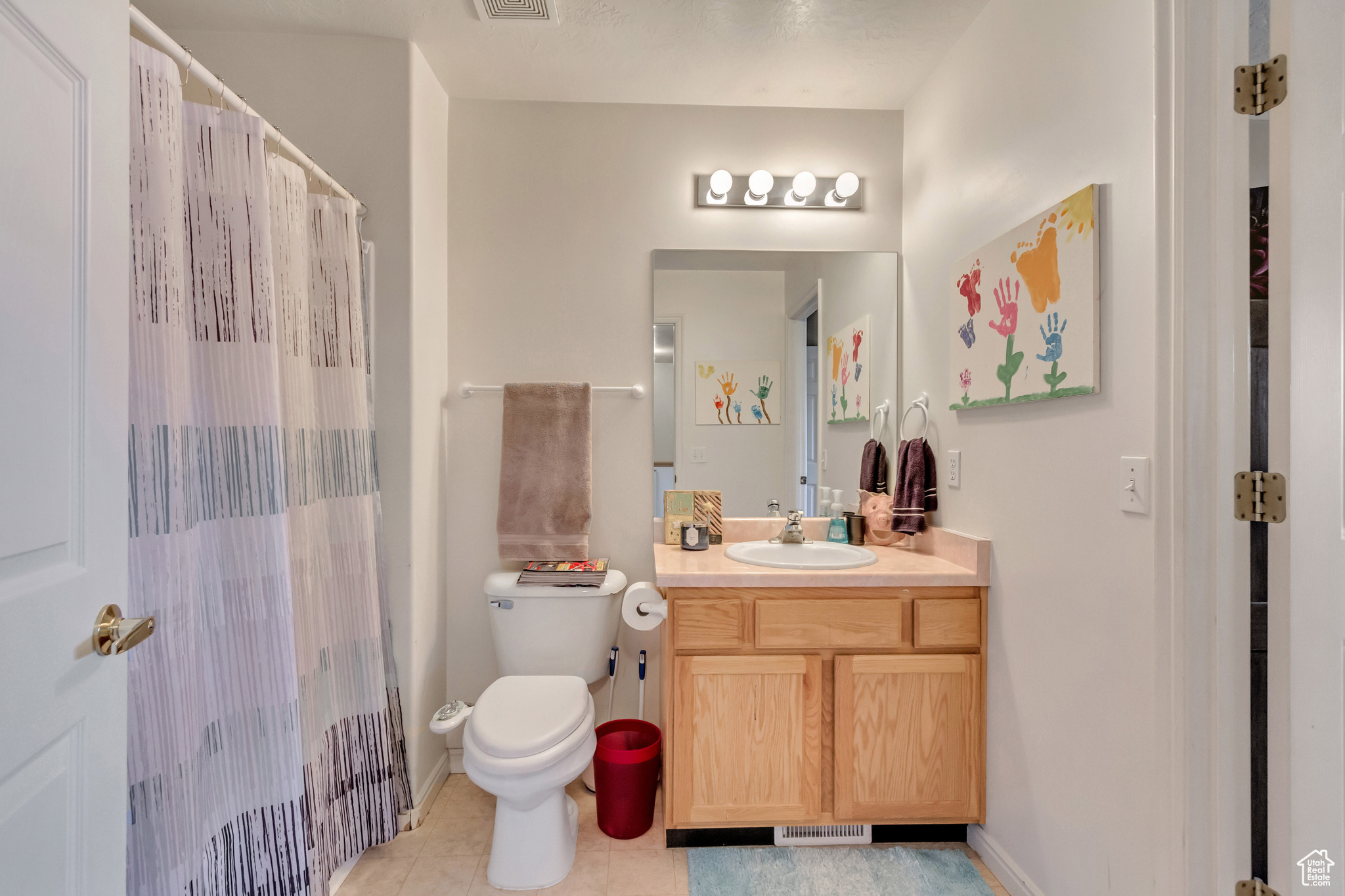 Bathroom featuring tile patterned floors, walk in shower, vanity, and toilet