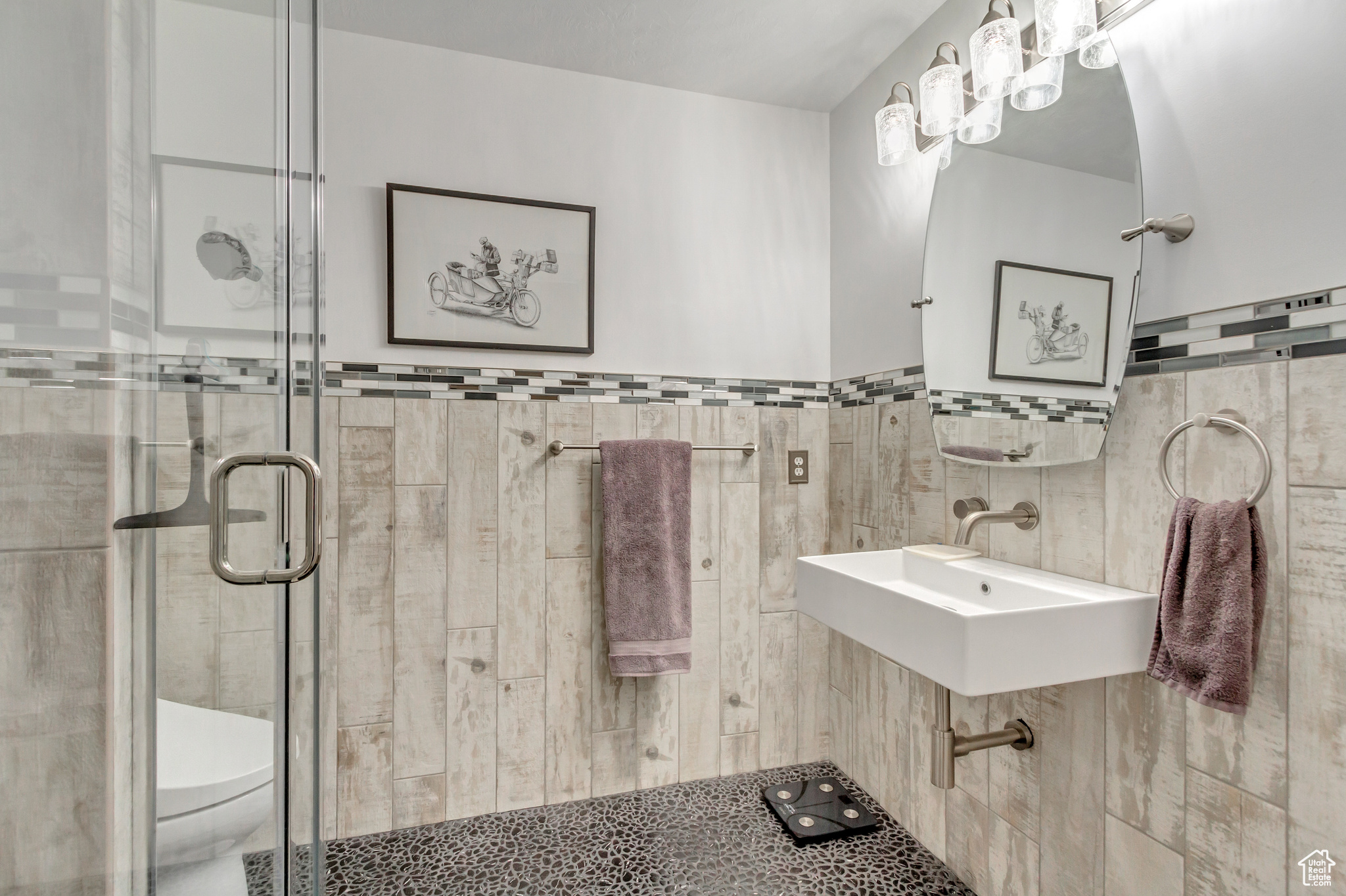 Bathroom featuring toilet, sink, tile walls, and walk in shower