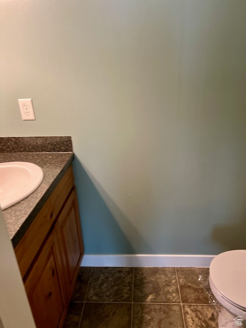 Bathroom featuring tile patterned flooring, vanity, and toilet