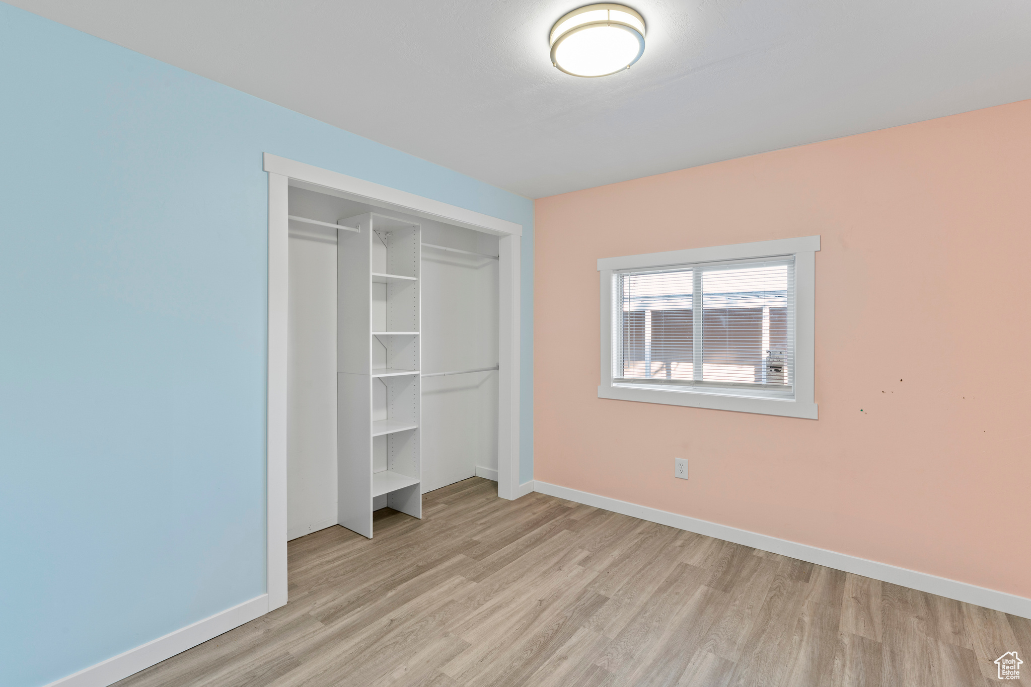 Unfurnished bedroom with light wood-type flooring and a closet