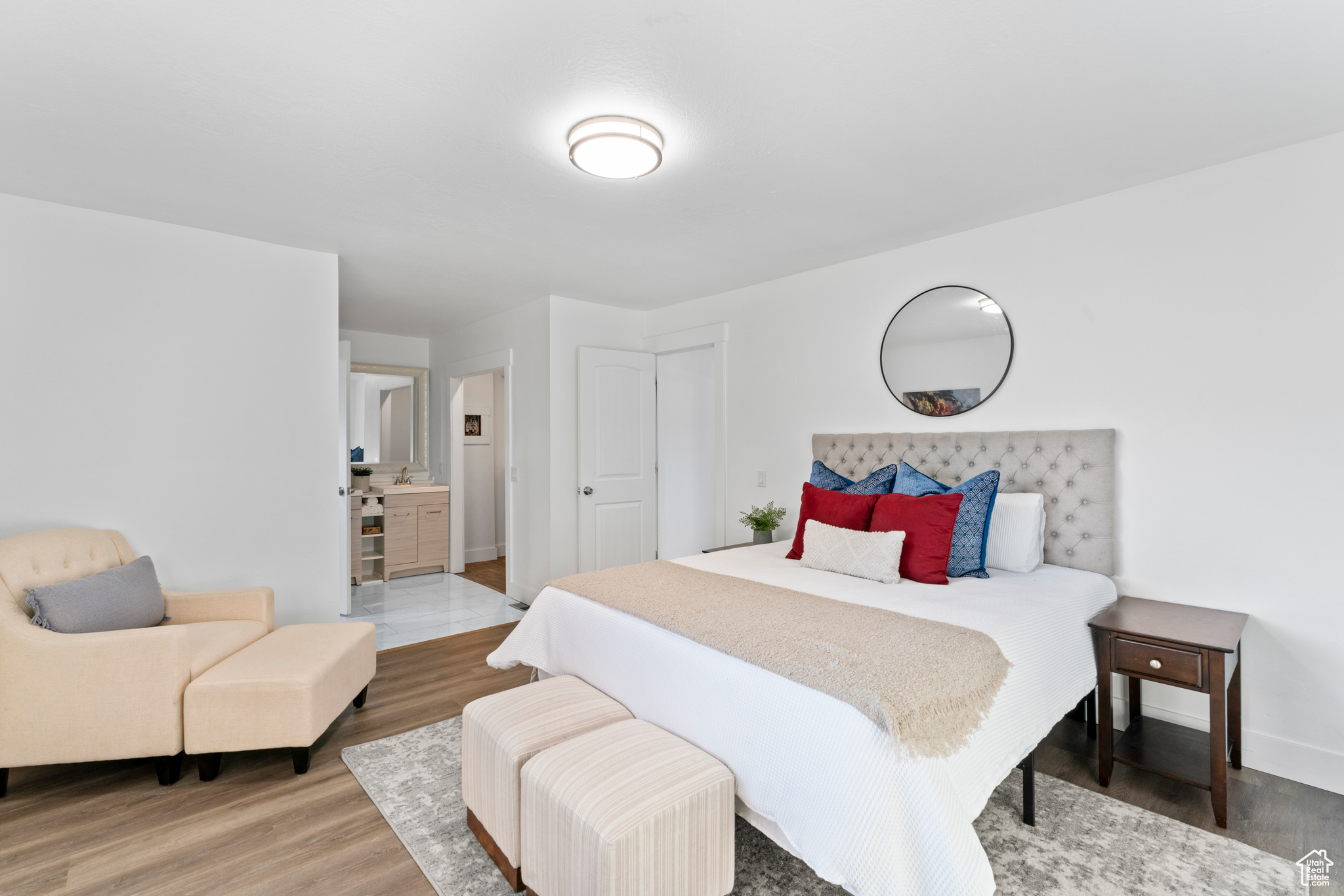 Bedroom featuring hardwood / wood-style flooring and connected bathroom