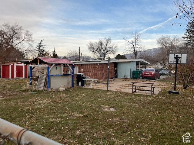 View of yard featuring a mountain view and a storage unit