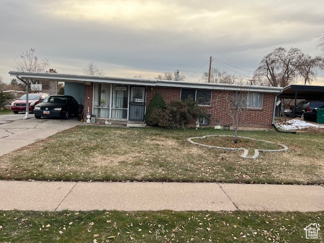 Ranch-style house with a carport and a front lawn