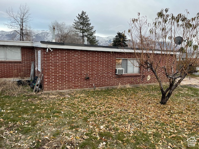 View of property exterior with a lawn and a mountain view