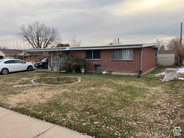 Ranch-style house with a carport and a front lawn