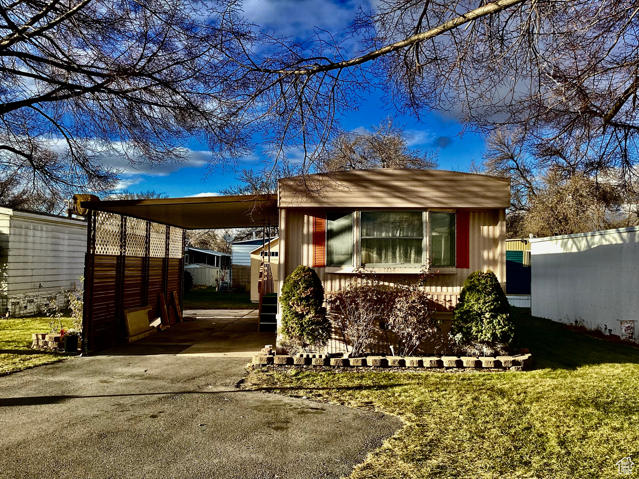 View of front of home featuring a front lawn and a carport