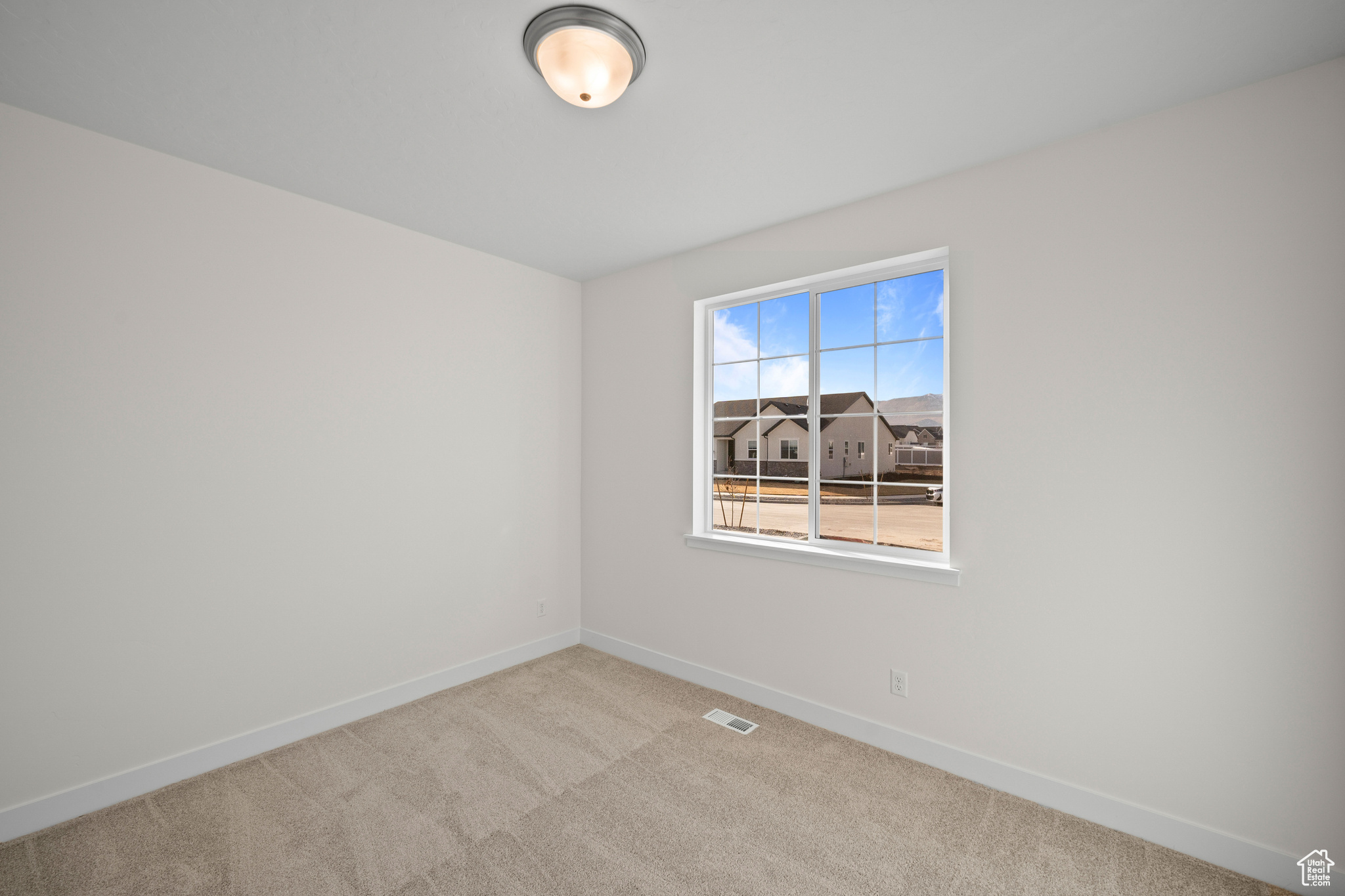 Empty room with light colored carpet