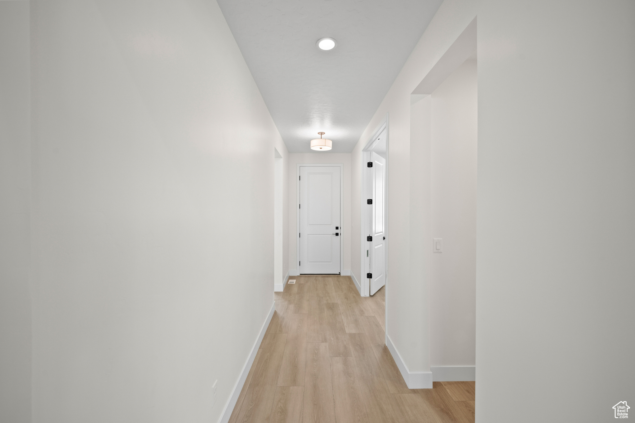 Hall with light hardwood / wood-style flooring