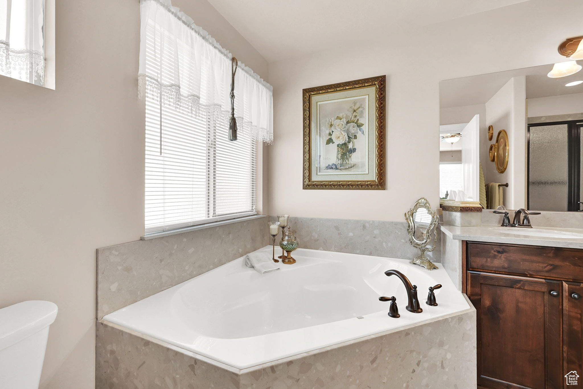 Bathroom with vanity, toilet, and tiled tub