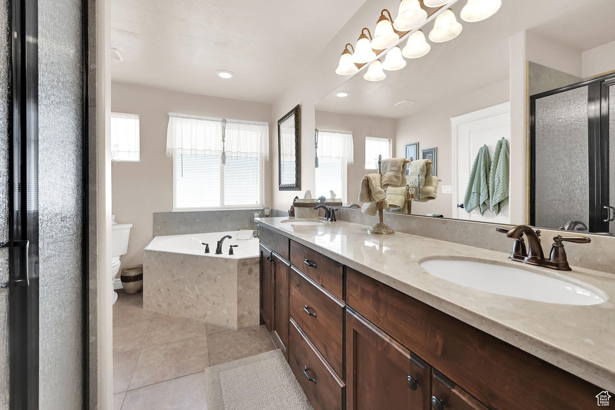 Full bathroom with tile patterned floors, a wealth of natural light, vanity, and separate shower and tub