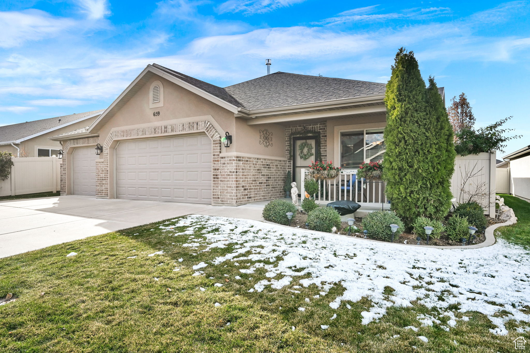 Single story home featuring covered porch and a garage