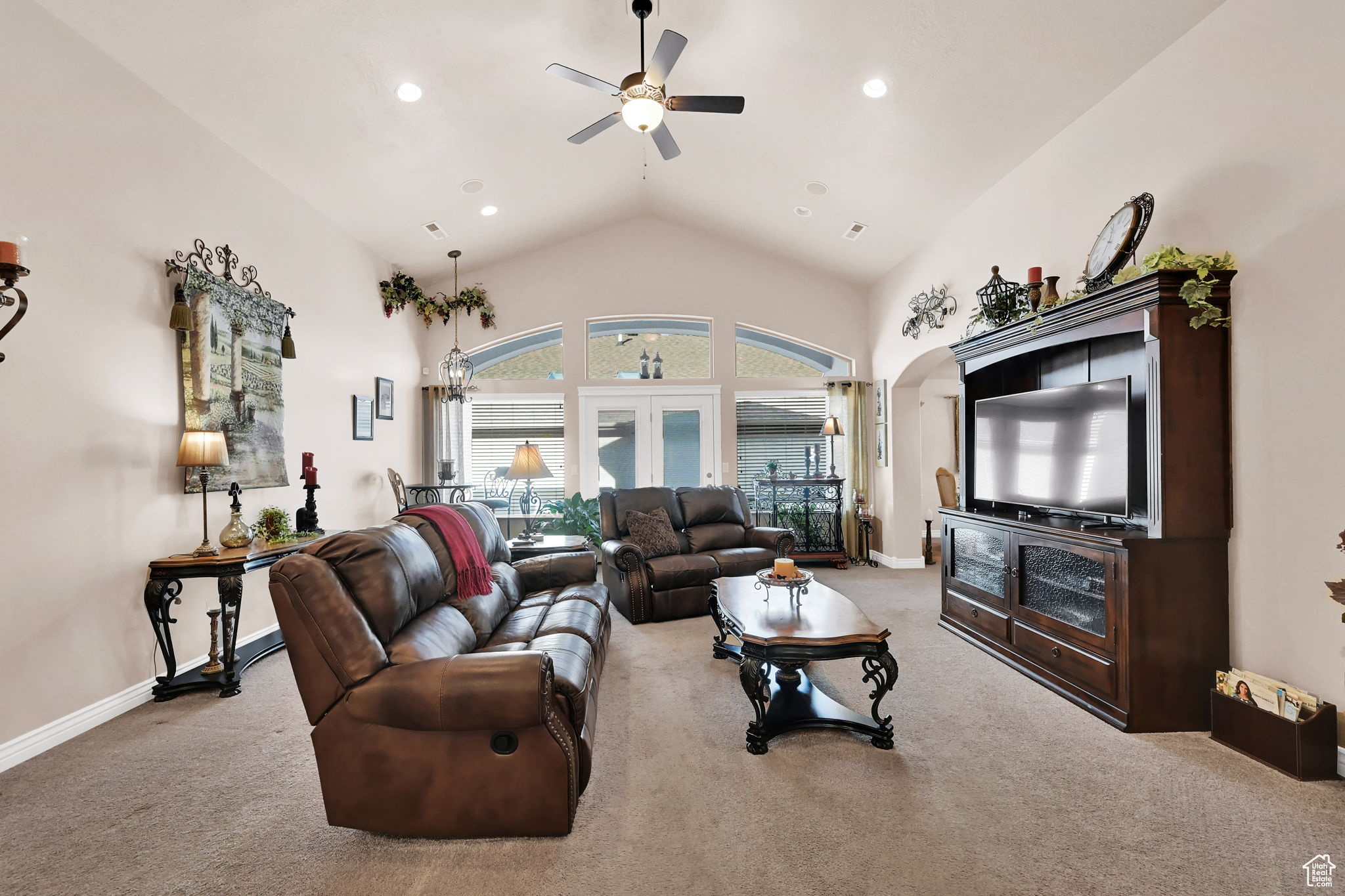 Living room featuring ceiling fan, light colored carpet, french doors, and vaulted ceiling