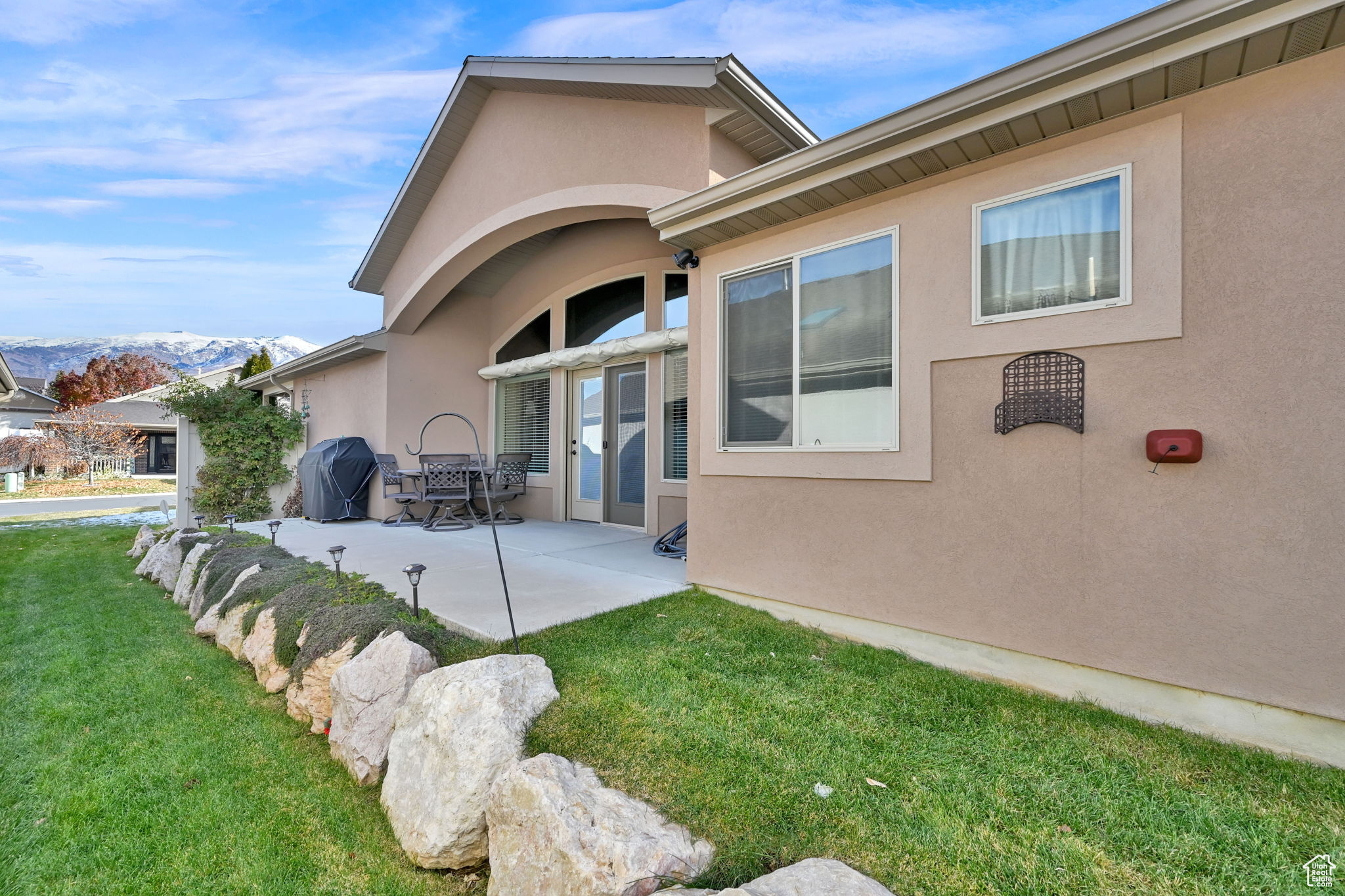 Rear view of house with a mountain view, a yard, and a patio