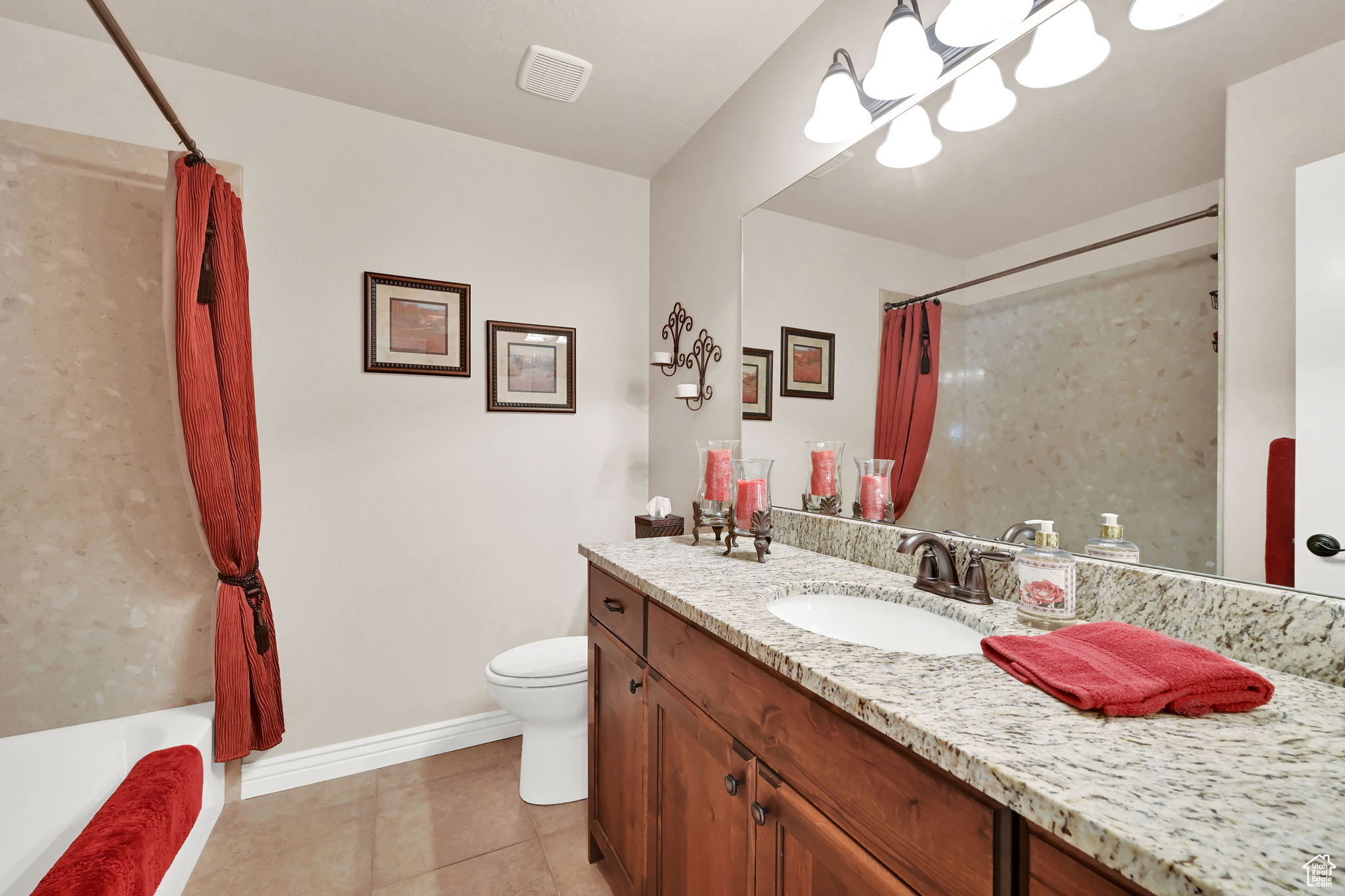 Full bathroom featuring tile patterned flooring, vanity, toilet, and shower / tub combo with curtain