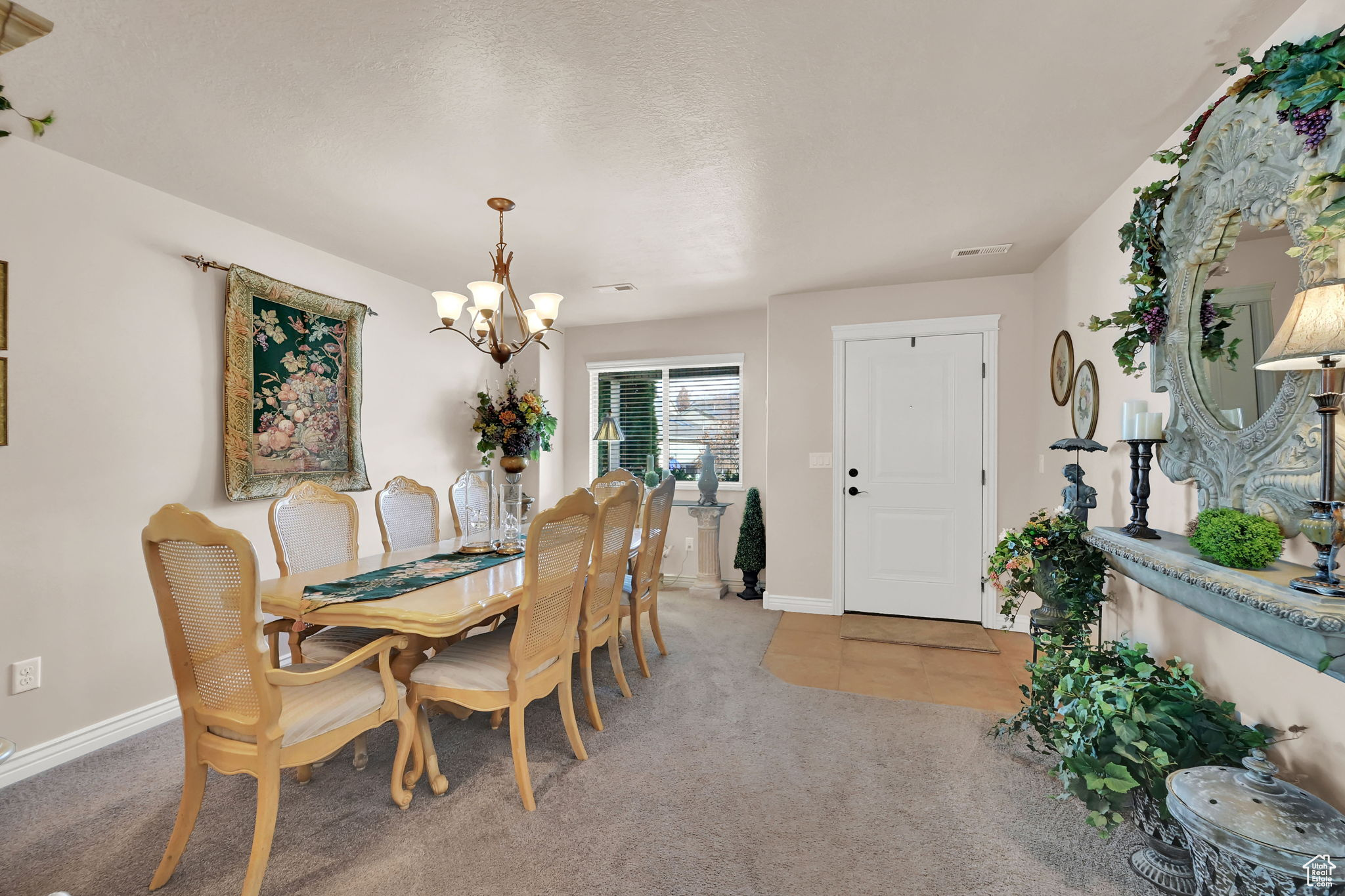 Dining room featuring a notable chandelier, carpet floors, and a textured ceiling