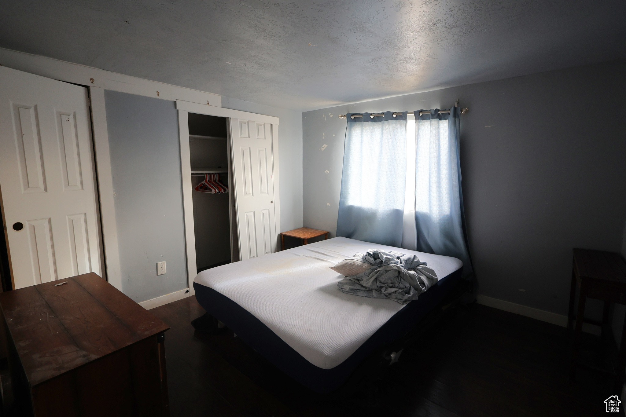 Bedroom with a textured ceiling and a closet