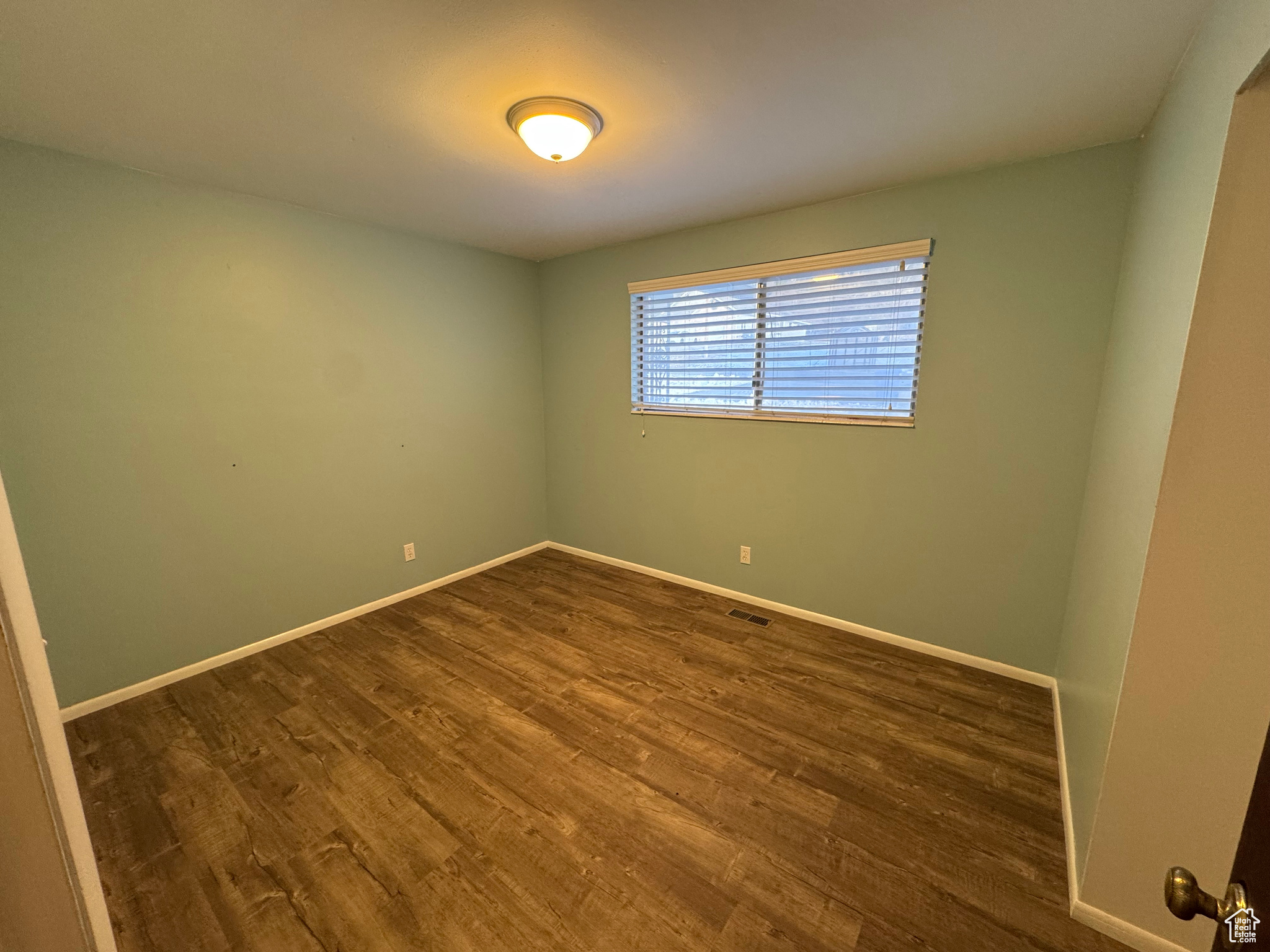 Spare room featuring dark wood-type flooring