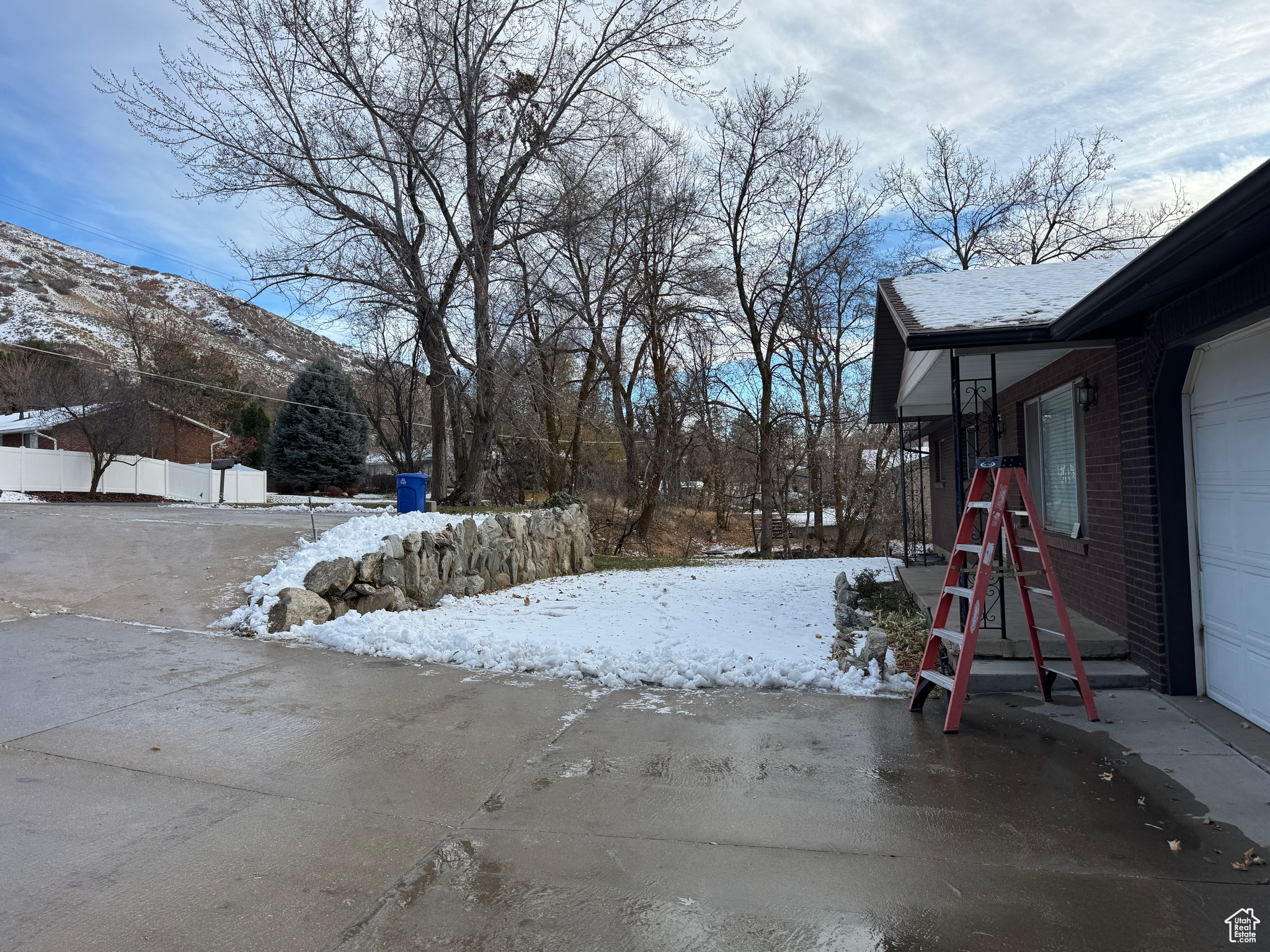 Snowy yard with a mountain view and a garage