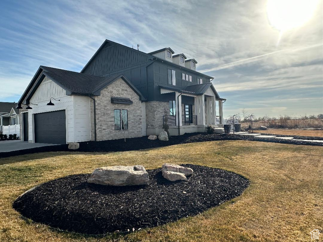 View of side of property with a lawn and a garage