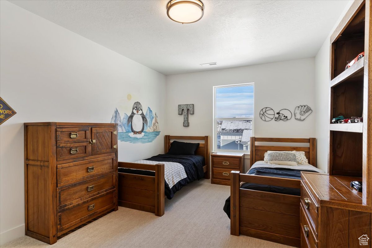 Carpeted bedroom with a textured ceiling