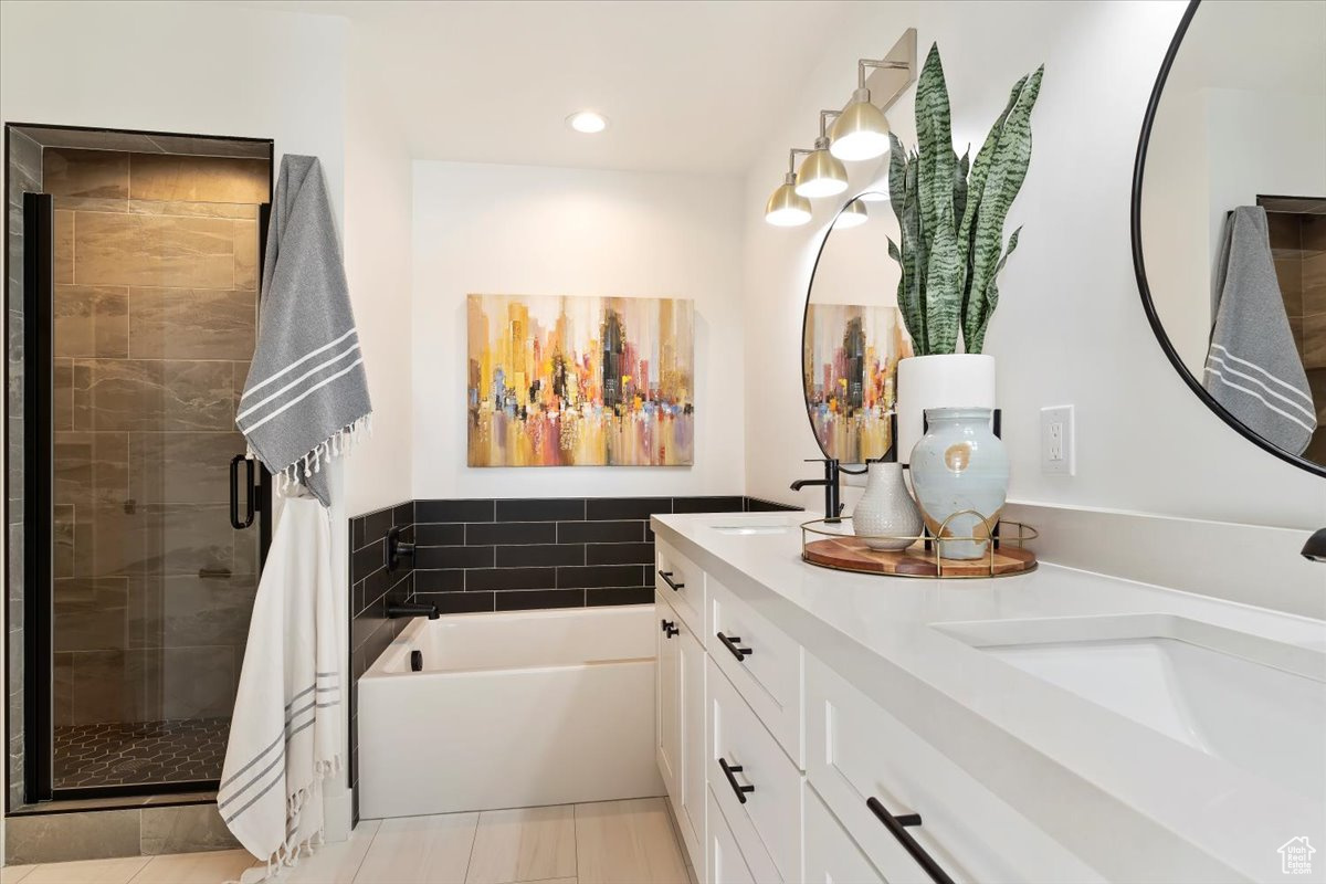 Bathroom with vanity, tile patterned flooring, and plus walk in shower