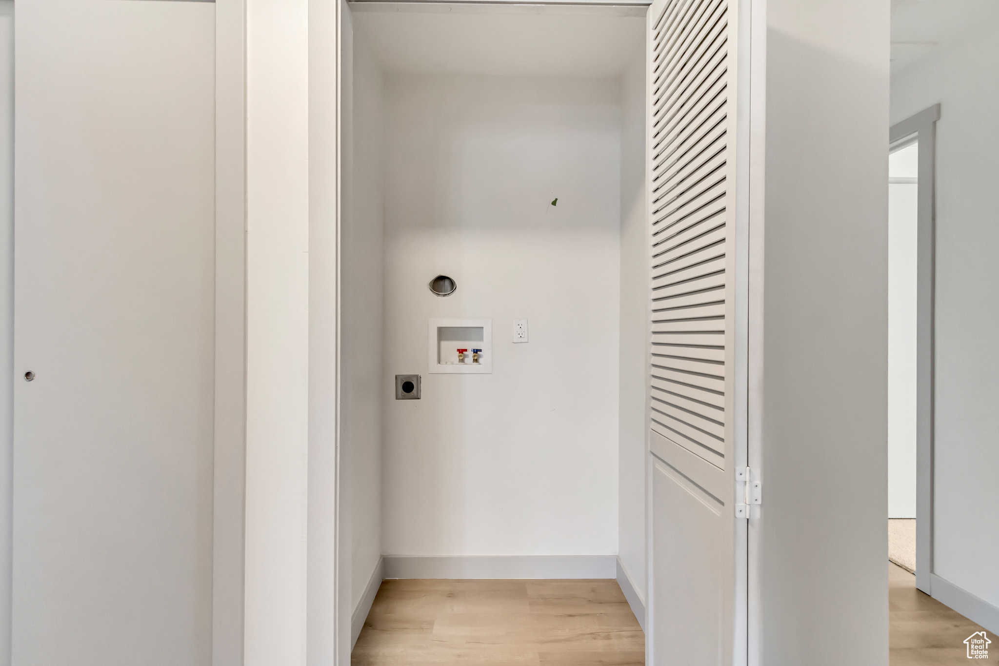 Washroom featuring hookup for an electric dryer, washer hookup, and light hardwood / wood-style flooring