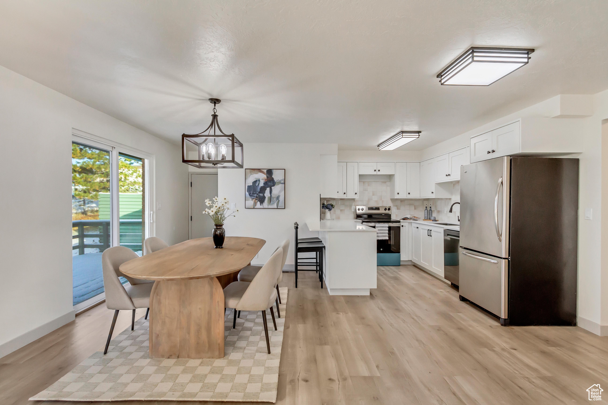 Dining space with light hardwood / wood-style floors and a chandelier