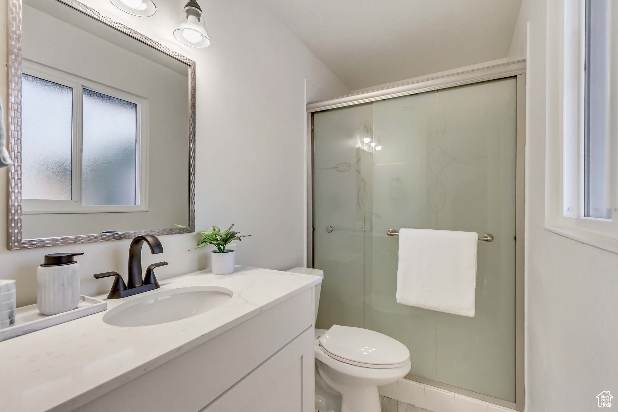 Bathroom with vanity, toilet, and a shower with door