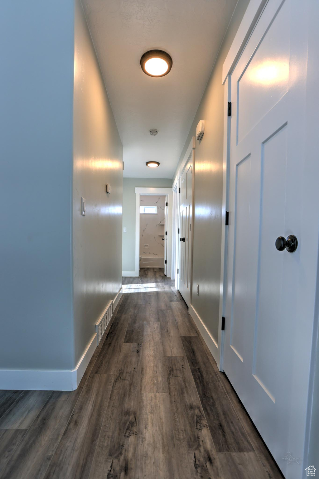 Corridor with dark hardwood / wood-style flooring