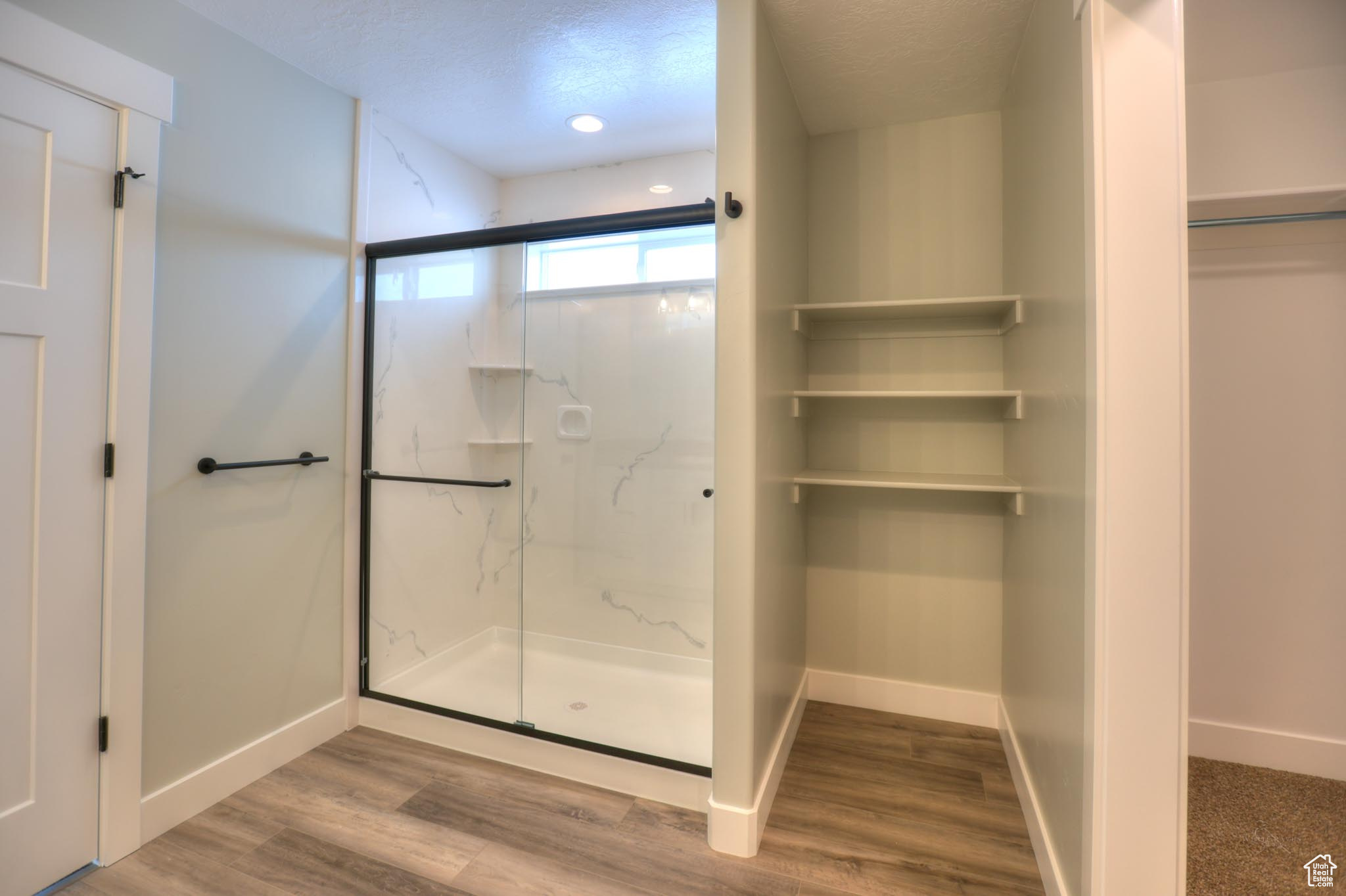 Master Bathroom featuring hardwood / wood-style floors, a textured ceiling, and an enclosed shower