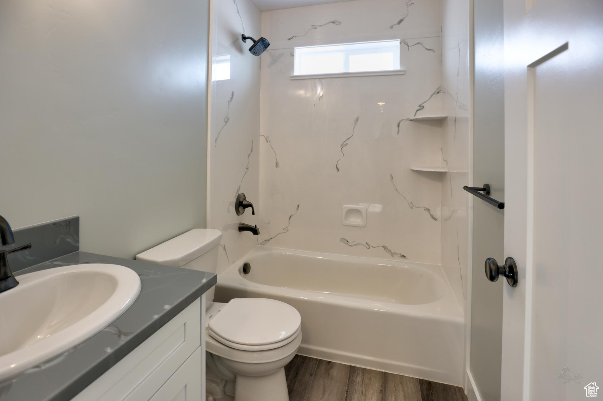 Full bathroom featuring toilet, hardwood / wood-style floors, vanity, and bathing tub / shower combination