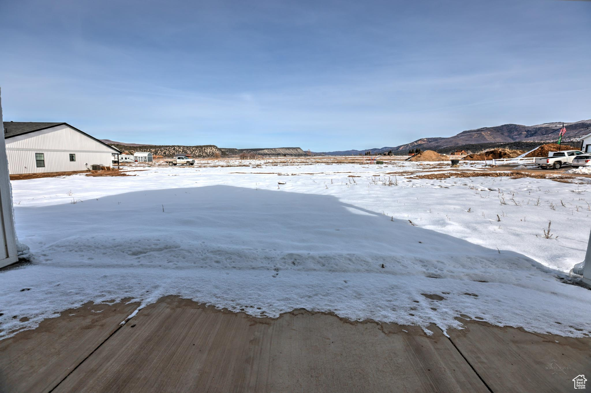 Yard covered in snow with a mountain view