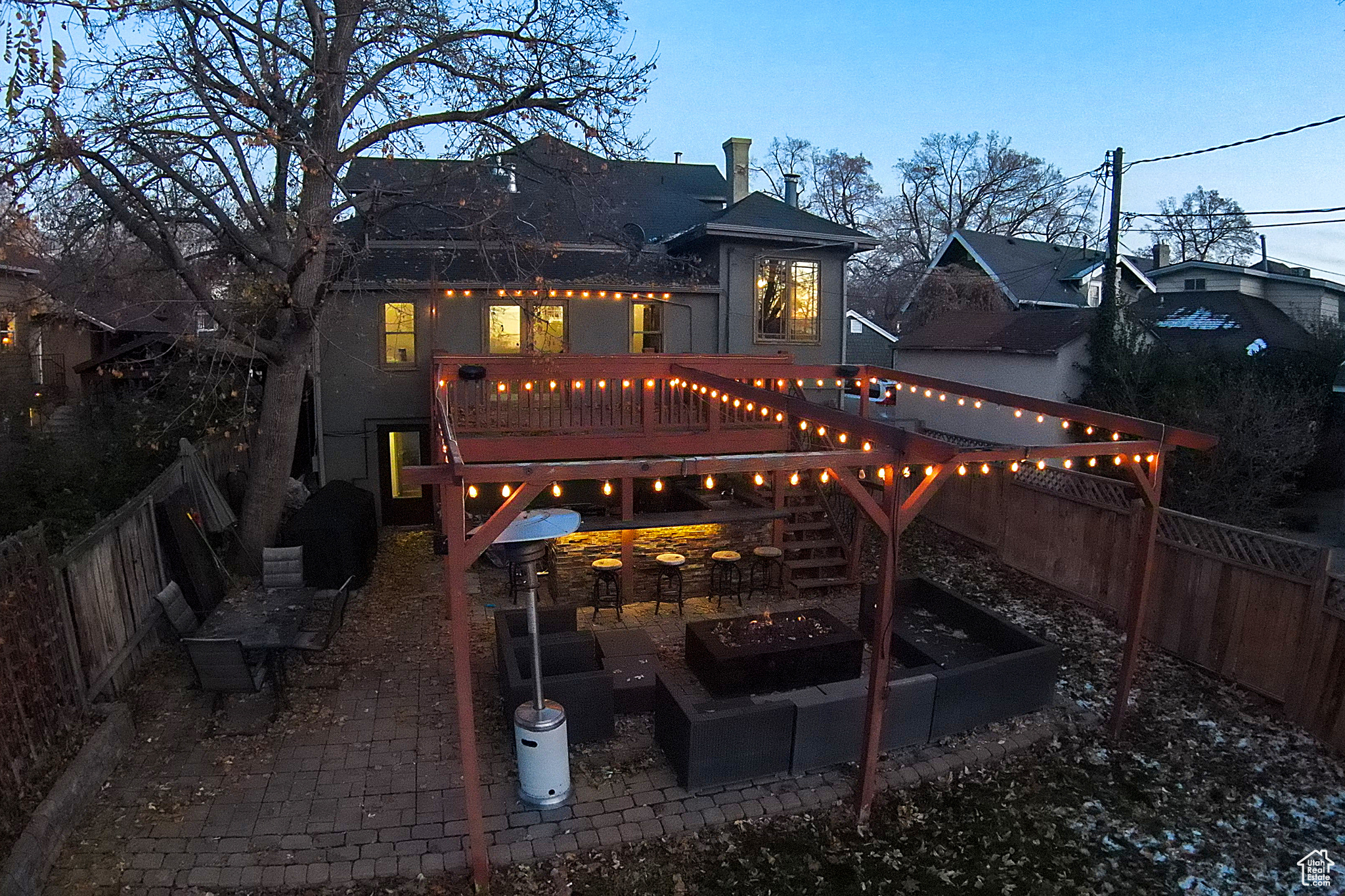 Back house at dusk with a fire pit and a deck