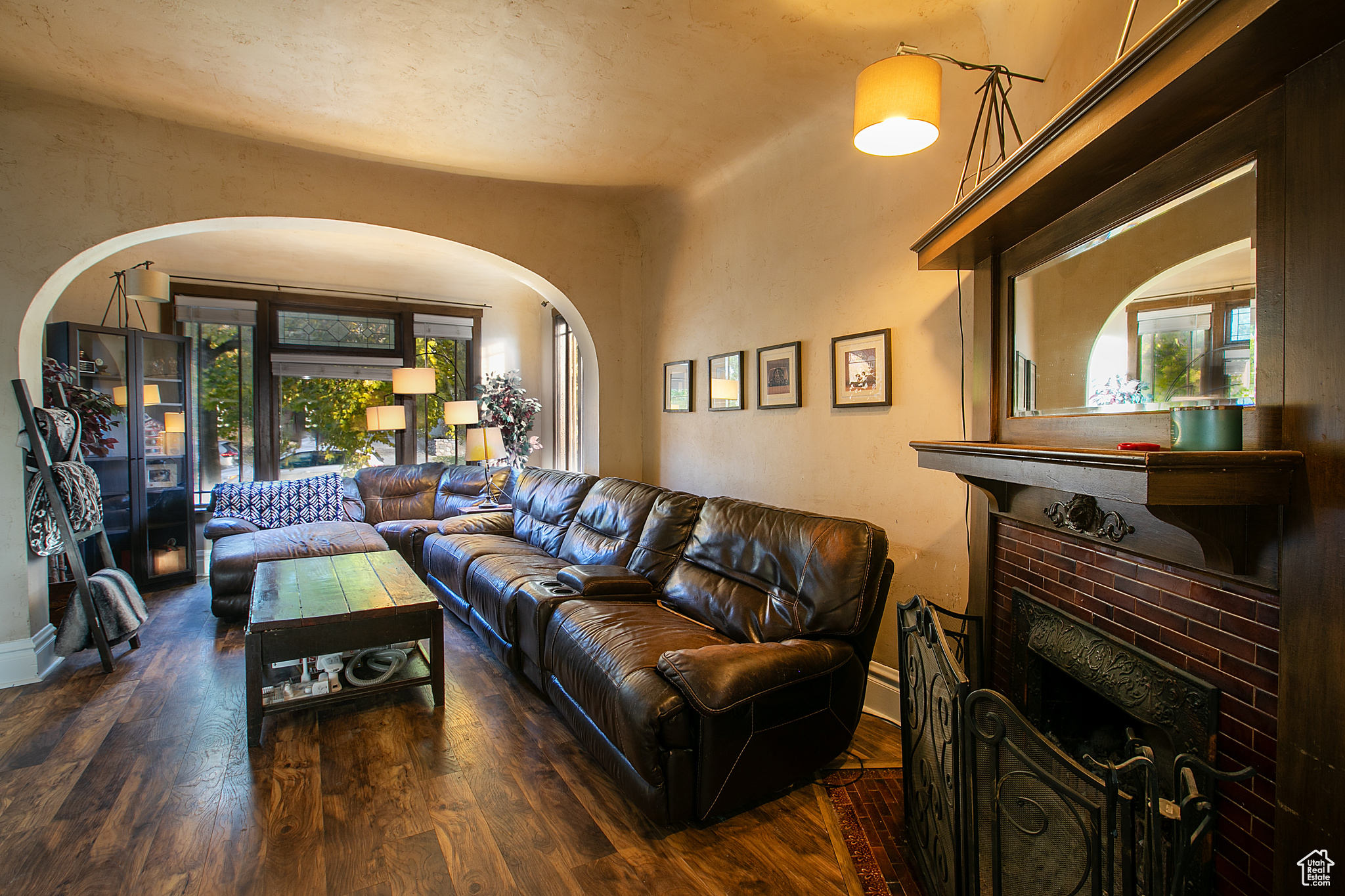 Living room featuring a brick fireplace and dark wood-type flooring