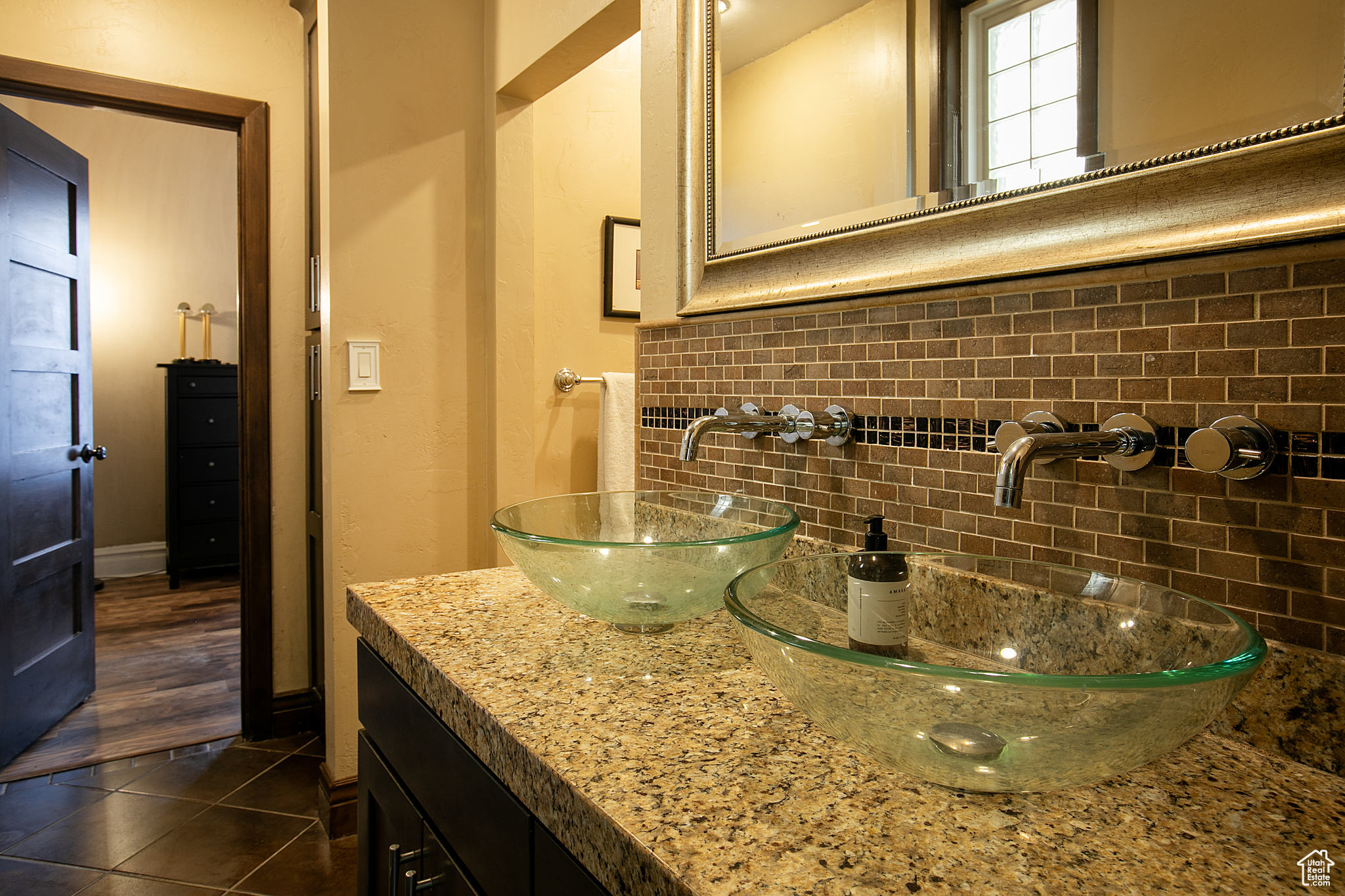 Bathroom with tile patterned flooring, vanity, and backsplash