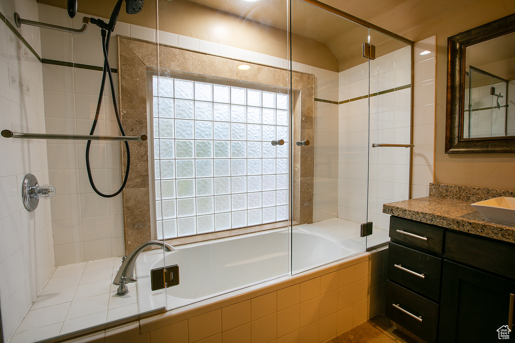 Bathroom with shower / bath combination with glass door, vanity, and lofted ceiling