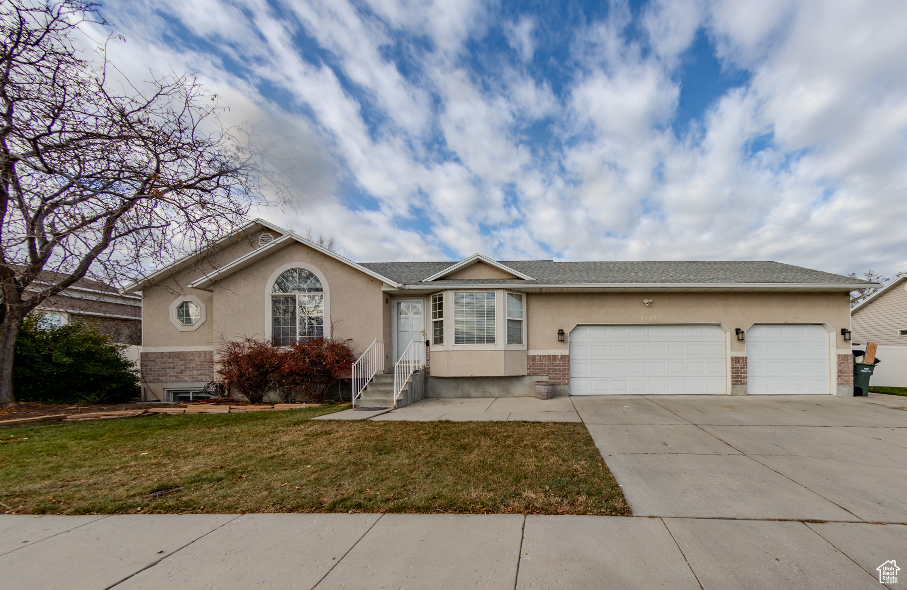 Single story home featuring a garage and a front yard