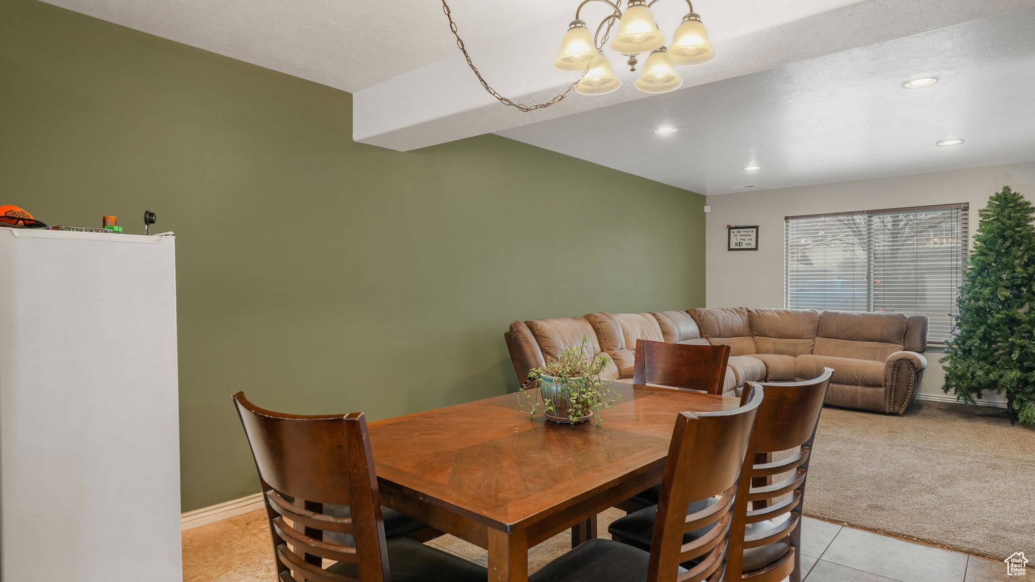 Tiled dining space featuring a chandelier and open concept