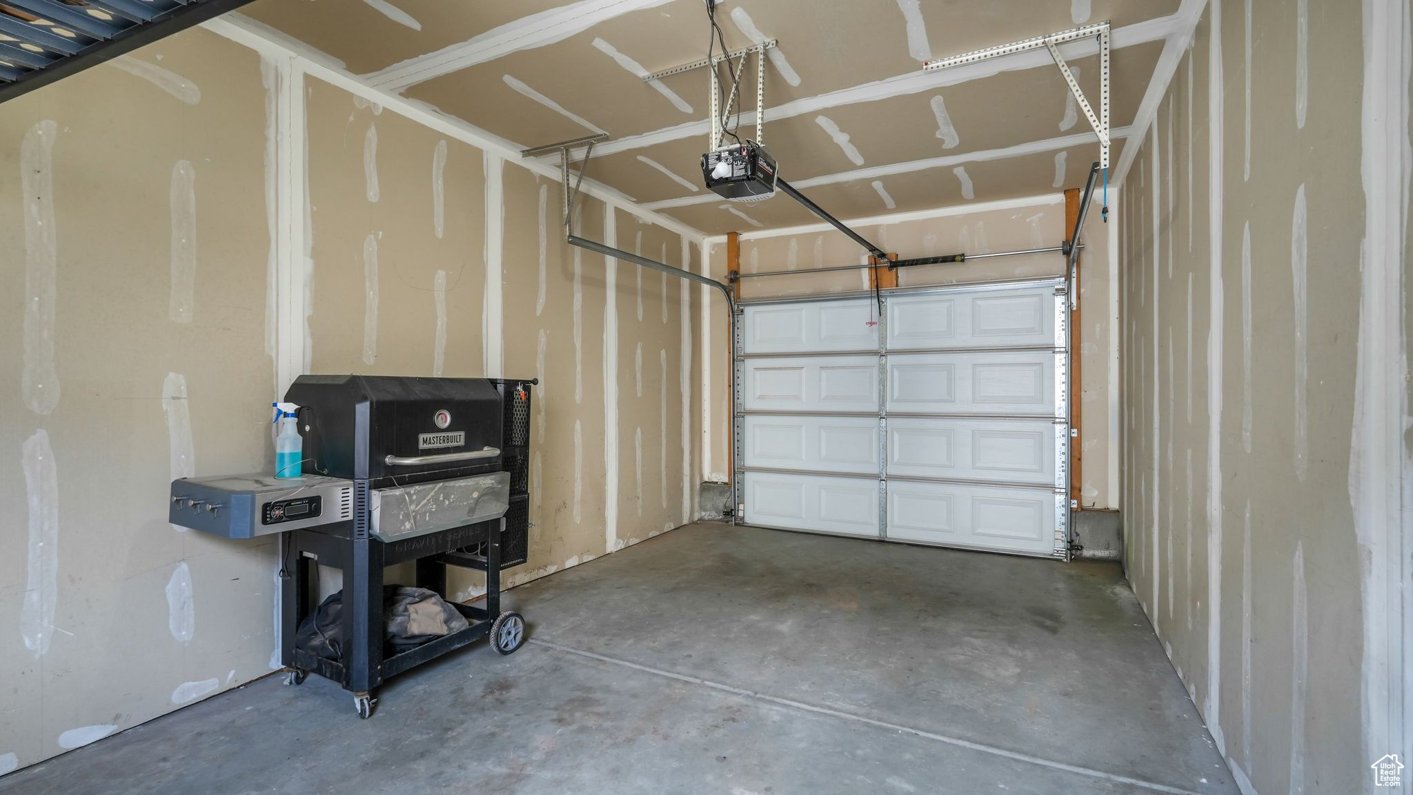 Garage featuring a garage door opener and additional overhead storage