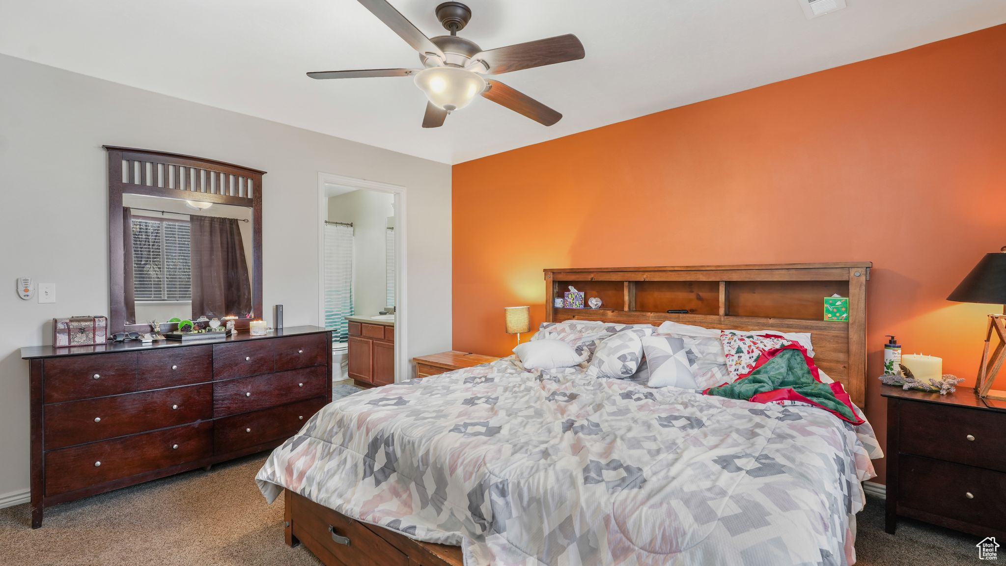 Carpeted master bedroom featuring ceiling fan and ensuite bathroom