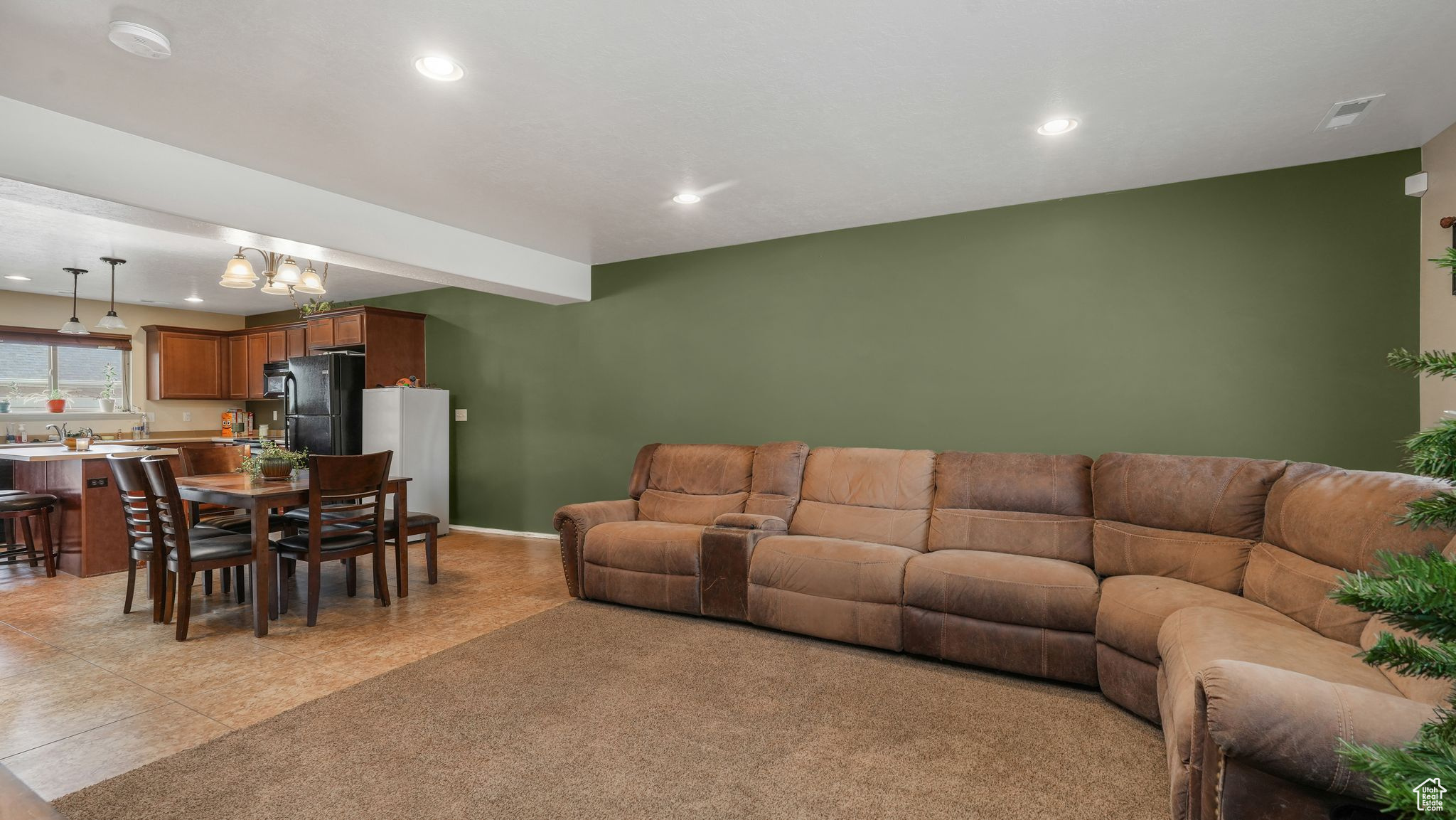 Living room featuring light colored carpet and a notable chandelier